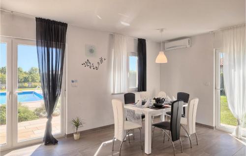een witte eetkamer met een witte tafel en stoelen bij Villa Rebici in Pula