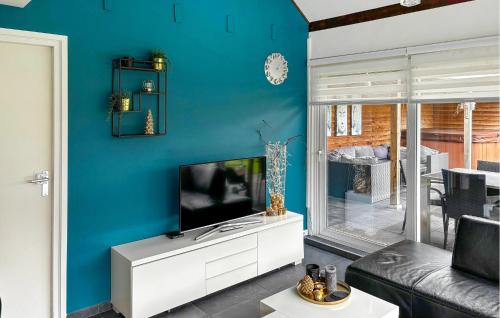 a living room with a tv on a blue wall at Oud Kempen Bungalow 181 in Stavenisse