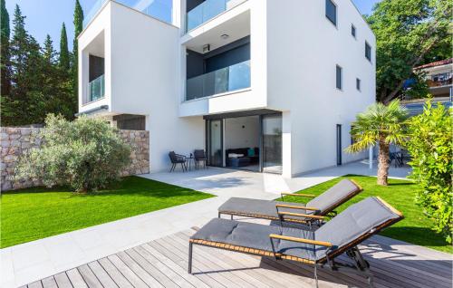 a white house with a patio and lawn at 2 Bedroom Stunning Apartment In Omisalj in Omišalj
