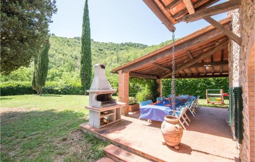 a patio with a table and an outdoor oven at Pet Friendly Home In Gaiole In Chianti in Gaiole in Chianti