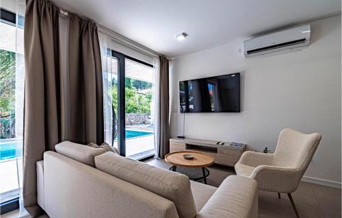 a living room with a couch and chairs and a tv at 3 Bedroom Nice Home In Prizba in Prizba