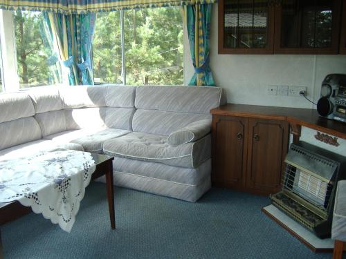 a living room with a white couch and a table at Višķezers in Višķi