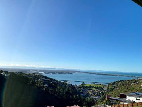 a view of a large body of water on a hill at Stunning sea, city & mountain views, 2 bedroom home, free parking, in brand new condition in Christchurch