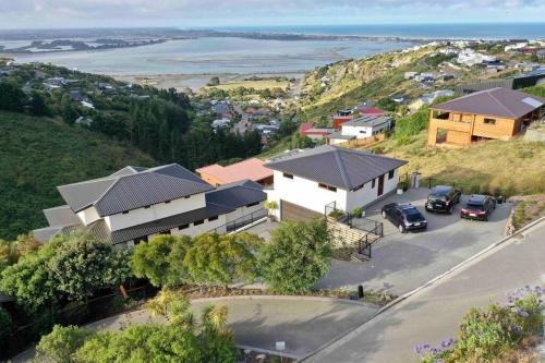 an aerial view of a house with cars parked in a driveway at Stunning sea, city & mountain views, 2 bedroom home, free parking, in brand new condition in Christchurch