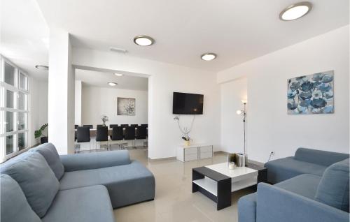 a living room with two blue couches and a tv at Ten-Bedroom Holiday Home In Duce in Tice