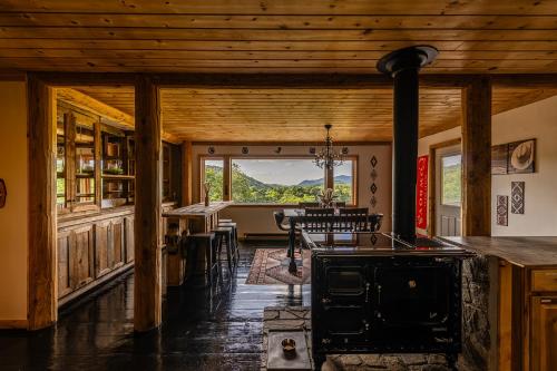 a kitchen with a stove and a dining room at Lodge Cabin Feed Brush Horses Mountain View Hot Tub Fireplace in Boone