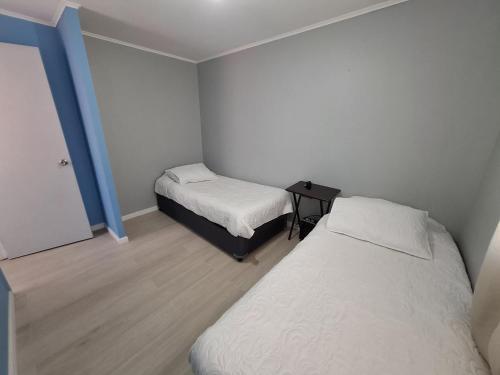 a small room with two beds and a table at Agradable casa en Puerto Varas in Puerto Varas