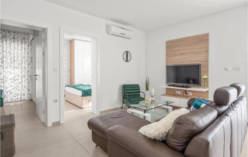 ein Wohnzimmer mit Ledercouch und Fernseher in der Unterkunft 4 Bedroom Amazing Apartment In in Srima