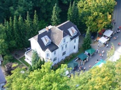 an aerial view of a large house with a group of people at Hotel Villa im Steinbusch in Malente