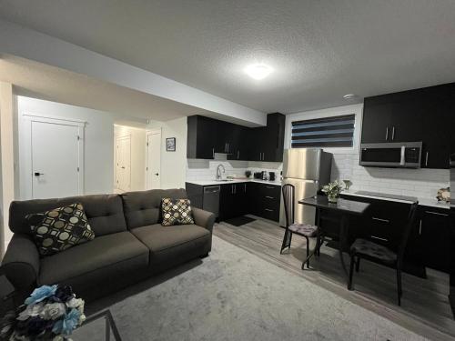 a living room with a couch and a kitchen at Arriva Homestay in Calgary