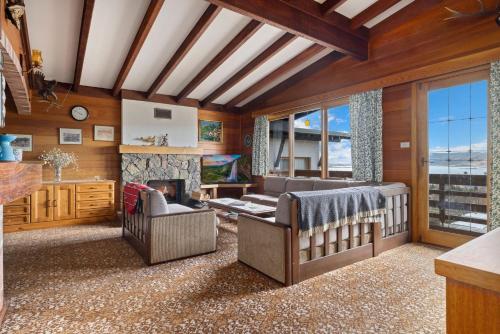a living room with a couch and a fireplace at Elvira Ski Haus in Jindabyne