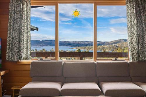 a couch sitting in front of a large window at Elvira Ski Haus in Jindabyne