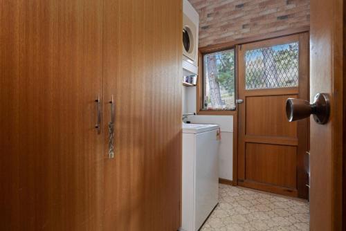 a bathroom with a door and a toilet and a window at Elvira Ski Haus in Jindabyne