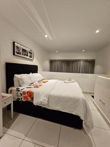a bedroom with a large bed with white sheets at Embassy Garden Luxury in Accra
