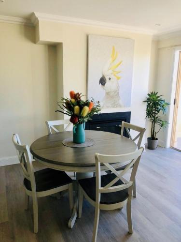 a dining room table with chairs and a vase of flowers at Nature at your Doorstep in Katoomba