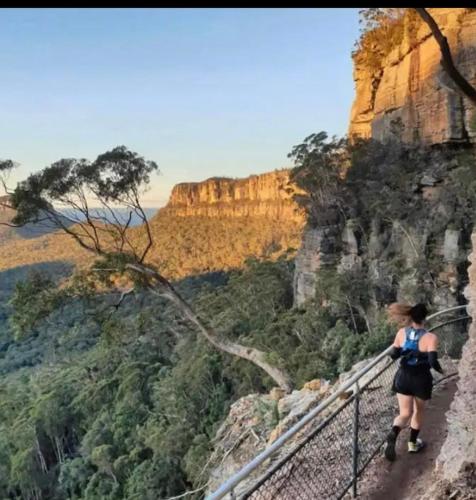 a woman walking on a suspension bridge over a canyon at Nature at your Doorstep in Katoomba