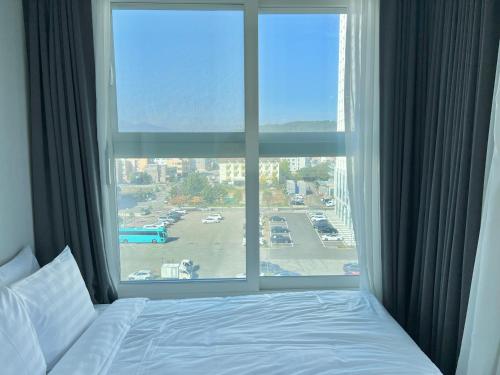 a bed in a hotel room with a large window at Le Bleu Naksan by Orot in Yangyang