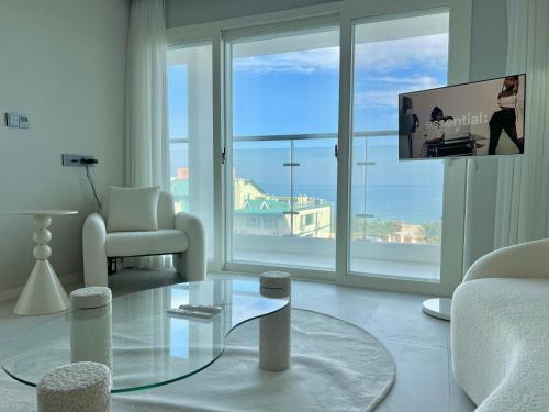a living room with a glass coffee table and a tv at Le Bleu Naksan by Orot in Yangyang