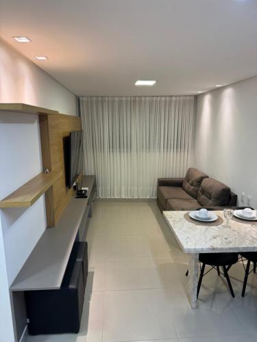a living room with a couch and a table at Apartamento em João Pessoa (Miramar) in João Pessoa