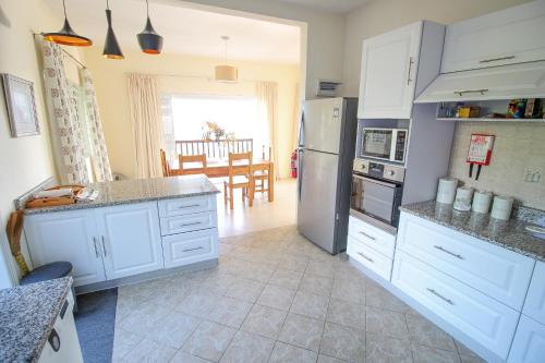 a kitchen with white cabinets and a stainless steel refrigerator at Kaz Bulinger in Machabee