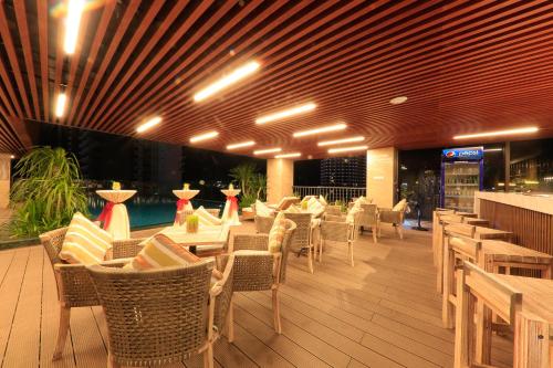 a restaurant with tables and chairs and a bar at Gonsala Hotel Nha Trang in Nha Trang