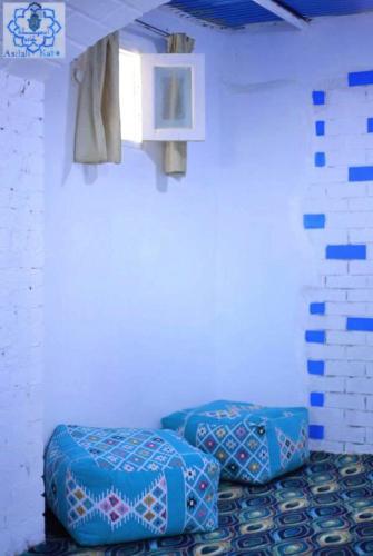 two blue ottomans in a room with a wall at Asilah kato nubian guest house in Aswan