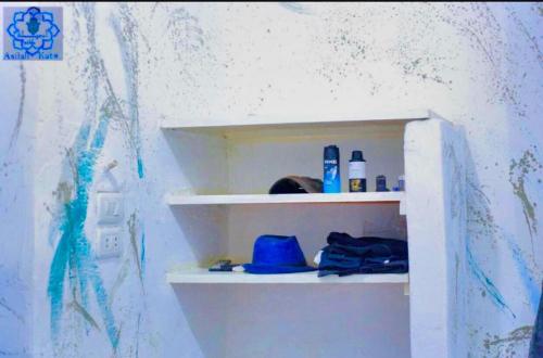 a shelf in a room with bottles on it at Asilah kato nubian guest house in Aswan