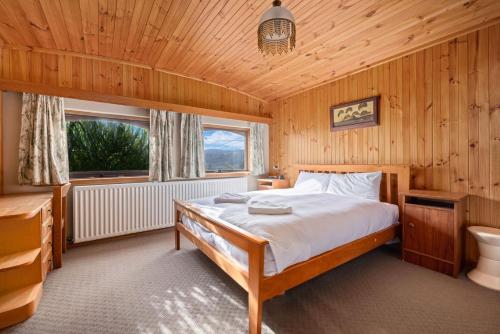 a bedroom with a bed in a wooden room at Elvira Ski Lodge in Jindabyne