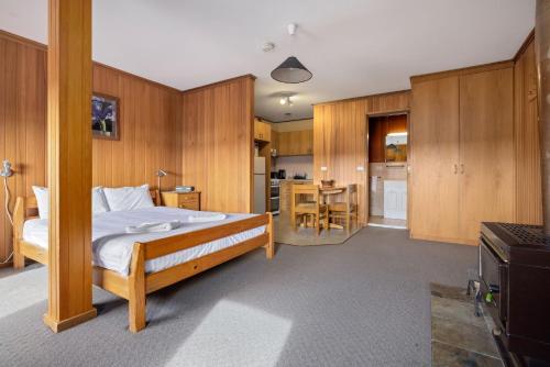 a bedroom with a bed and a kitchen with a table at Elvira Ski Lodge in Jindabyne