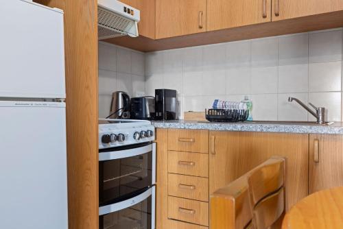a kitchen with a stove and a sink at Elvira Ski Lodge in Jindabyne