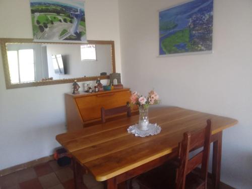 une table de salle à manger avec un vase de fleurs dessus dans l'établissement LINDO APTO CENTRAL, QUASE ao LADO DO HOTEL NACIONAL CORUMBÁ -MS, à Corumbá