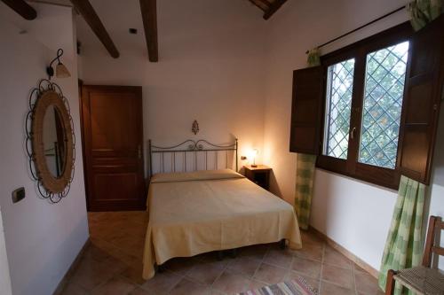 1 dormitorio con cama, ventana y espejo en Agriturismo Baglio Donna Santa, en Dattilo