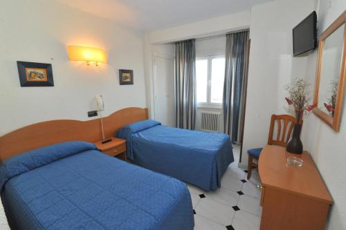 A bed or beds in a room at Hostal Goyma I