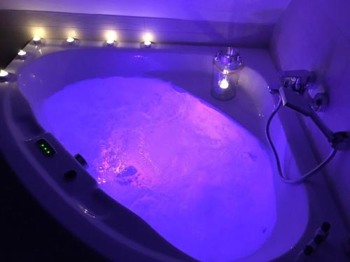 a purple bath tub with a candle in it at Landhaus Moselschön in Alken
