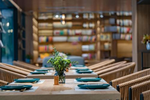 a long table with blue plates and a vase of flowers at iTree Guanhu Academy Huizhou West Lake in Huizhou