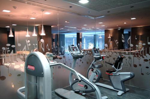 a gym with treadmills and ellipticals in a room at Primus Valencia in Valencia