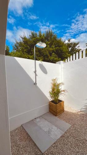 a white fence with a light next to a plant at Kaz 4 plages - Accès plages & Vue Mer in Deshaies