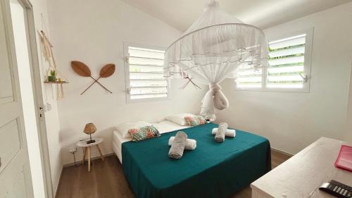 a bedroom with a bed with two stuffed animals on it at Kaz 4 plages - Accès plages & Vue Mer in Deshaies