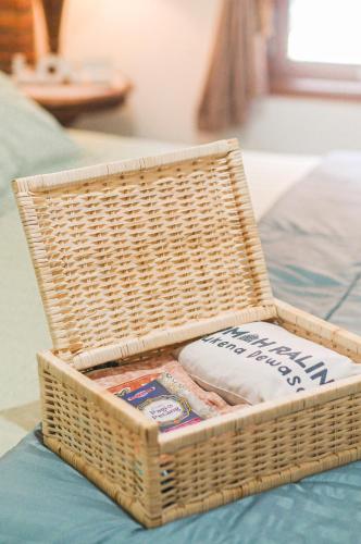 a wicker basket sitting on top of a bed at Omah Ralin Family Homestay with Spacious Joglo House in Timuran