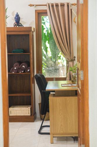 a room with a desk and a window at Omah Ralin Family Homestay with Spacious Joglo House in Timuran