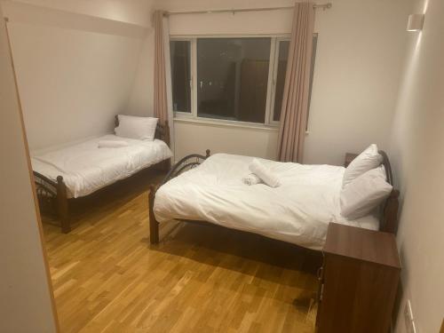 Una pequeña habitación con dos camas y una ventana. en One bed room near Wembley stadium, en Preston
