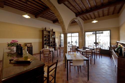 ein Restaurant mit Tischen und Stühlen in einem Zimmer in der Unterkunft Agriturismo Bagnaia in San Quirico dʼOrcia