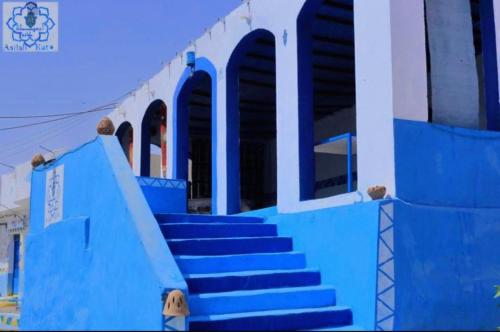 a blue and white building with blue steps at Asilah kato nubian guest house in Aswan
