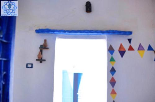 a room with a door and a wall with flags at Asilah kato nubian guest house in Aswan