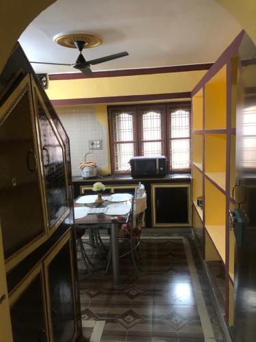 a kitchen with a table and a ceiling fan at Kodali Homestays in Bhadrāchalam