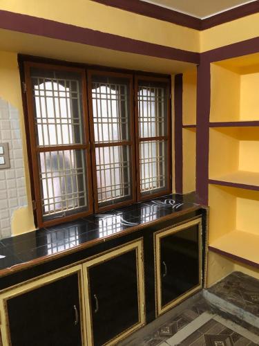 a room with a counter with windows in a room at Kodali Homestays in Bhadrāchalam