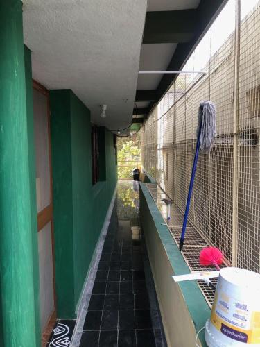 a building with a green wall and a bird cage at Kodali Homestays in Bhadrāchalam