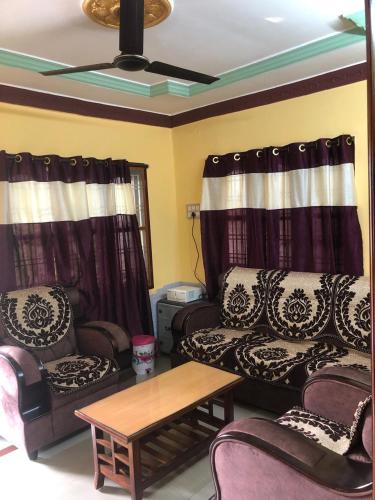 a living room with two couches and a coffee table at Kodali Homestays in Bhadrāchalam