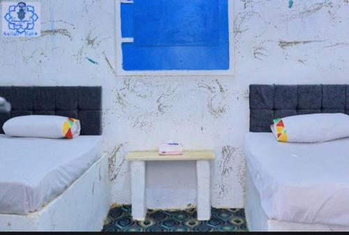 a room with two beds and a small table at Asilah kato nubian guest house in Aswan