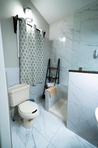 a bathroom with a toilet and a shower and a sink at Oakridge Apartment in Spanish Lookout